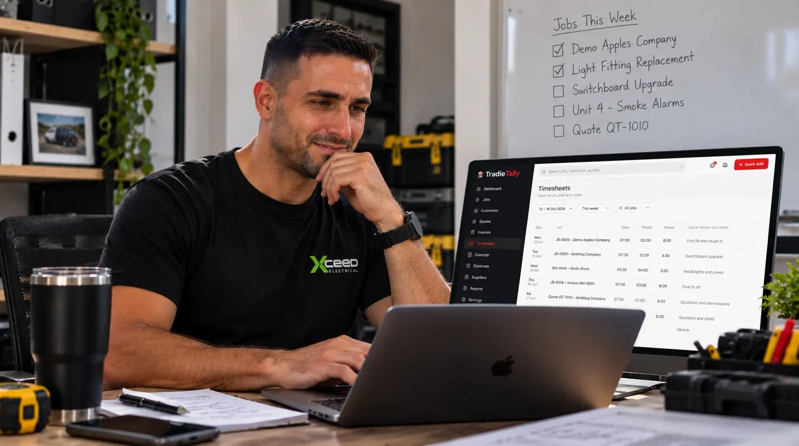 Jayson Conceicao, electrician and TradieTally founder, at his desk checking weekly timesheets in TradieTally on a laptop and monitor