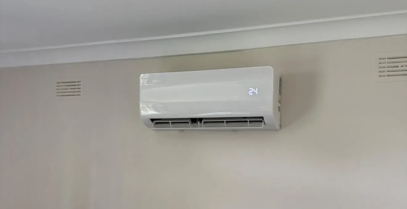 A newly installed white wall split system air conditioner below the cornice, set to 24 degrees